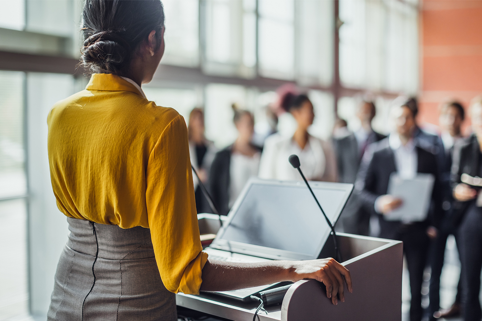 A woman at a podium addressing a group of people