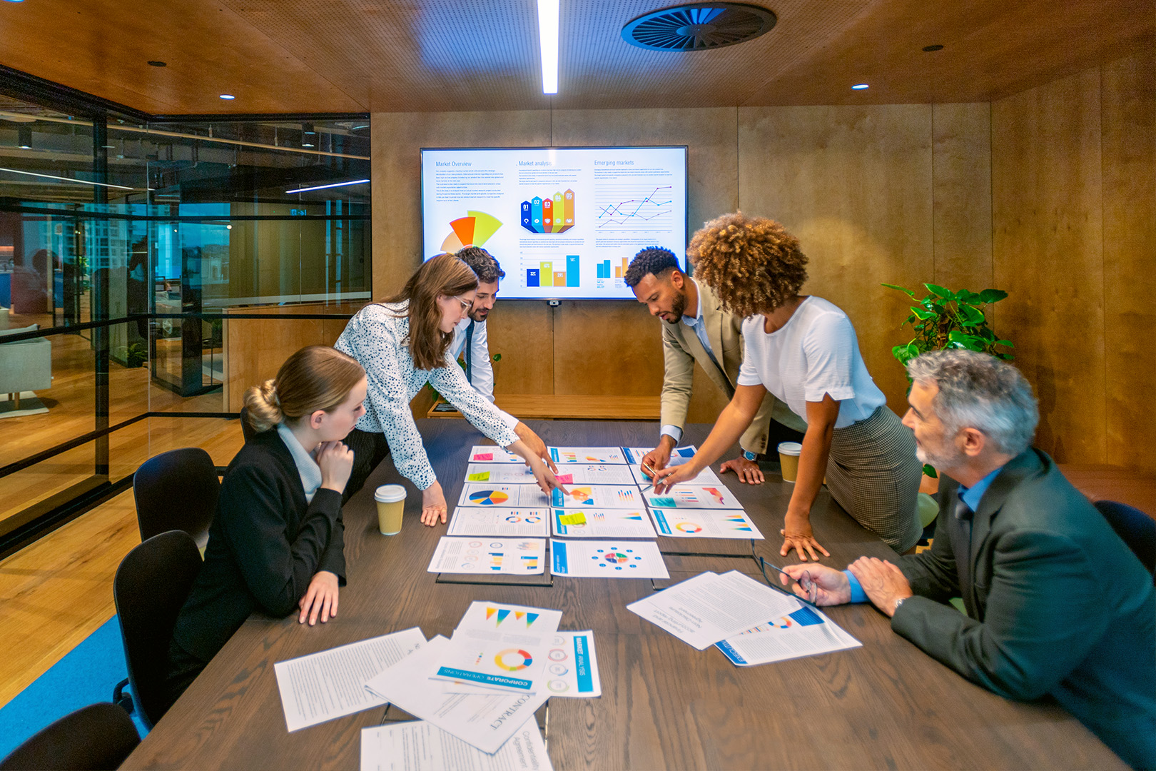 A group of people looking over documents in a board room