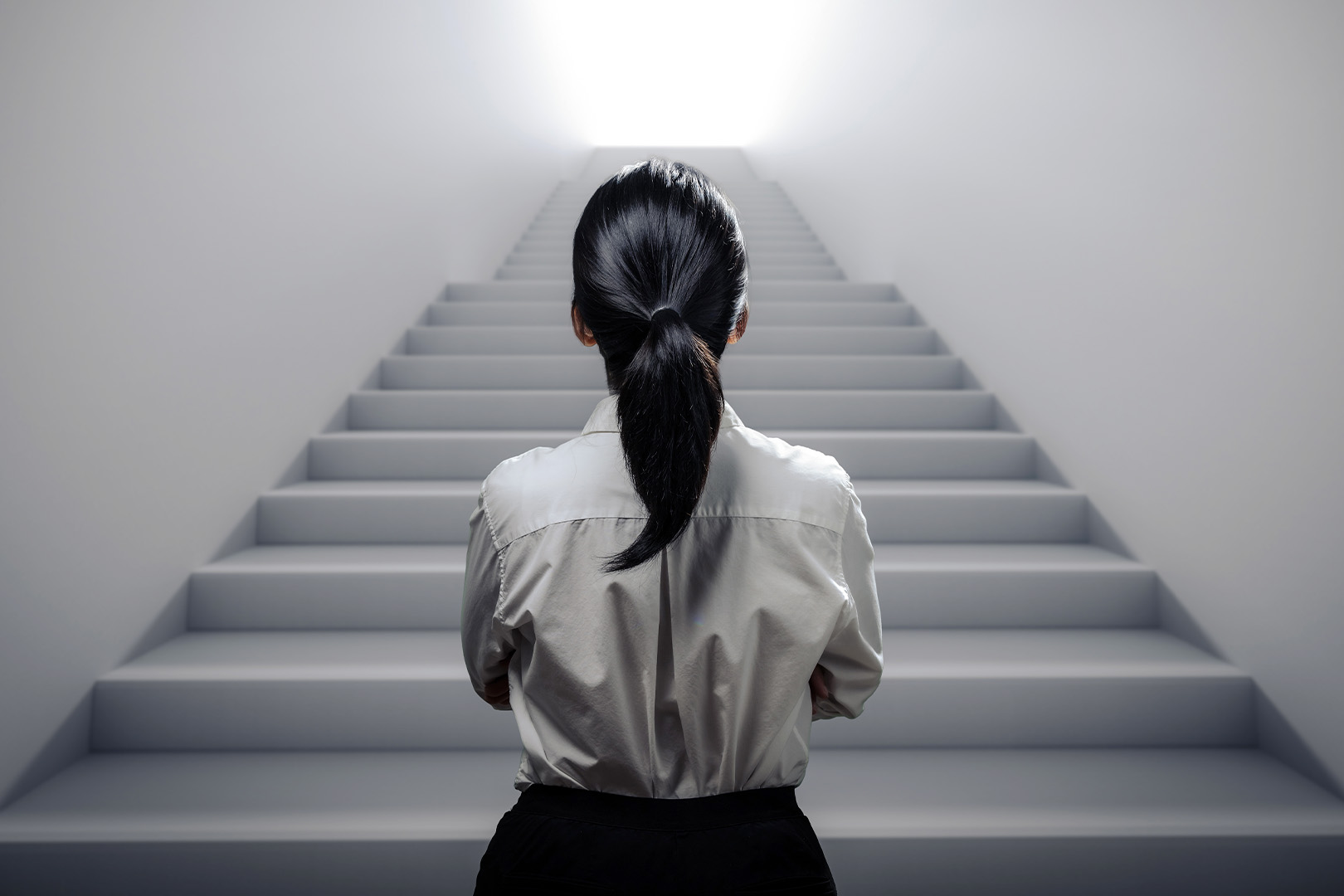 A person looking up at a flight of stairs