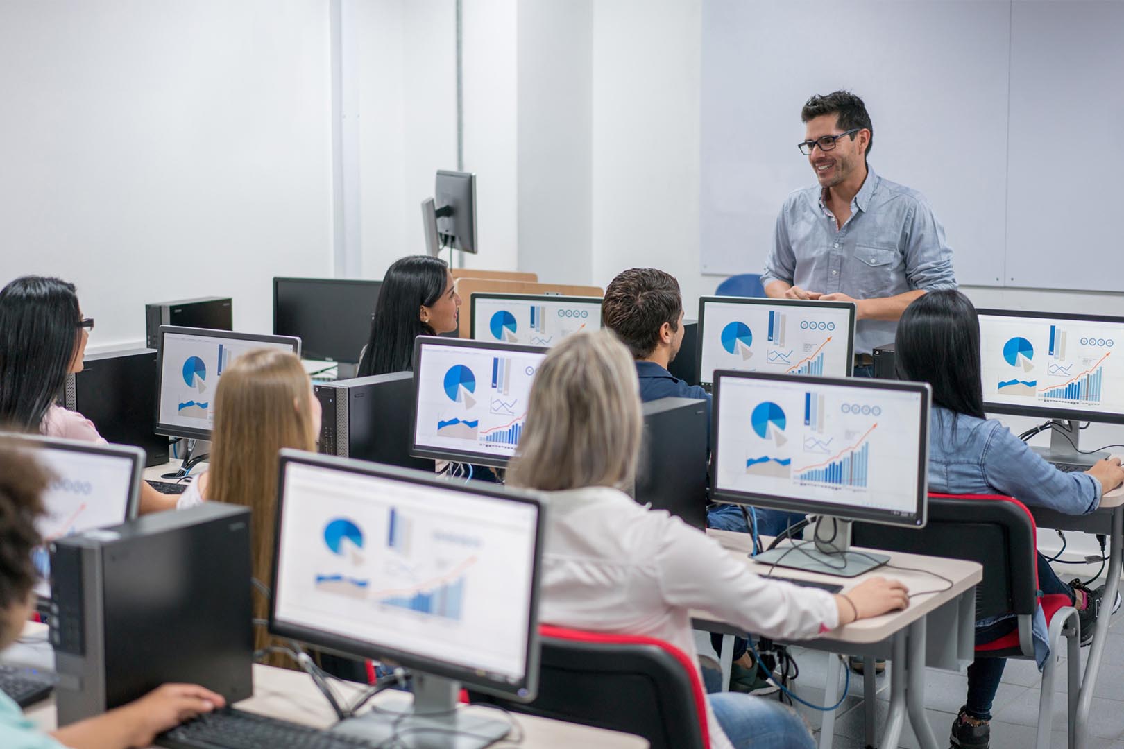 People behind computer screens in classroom