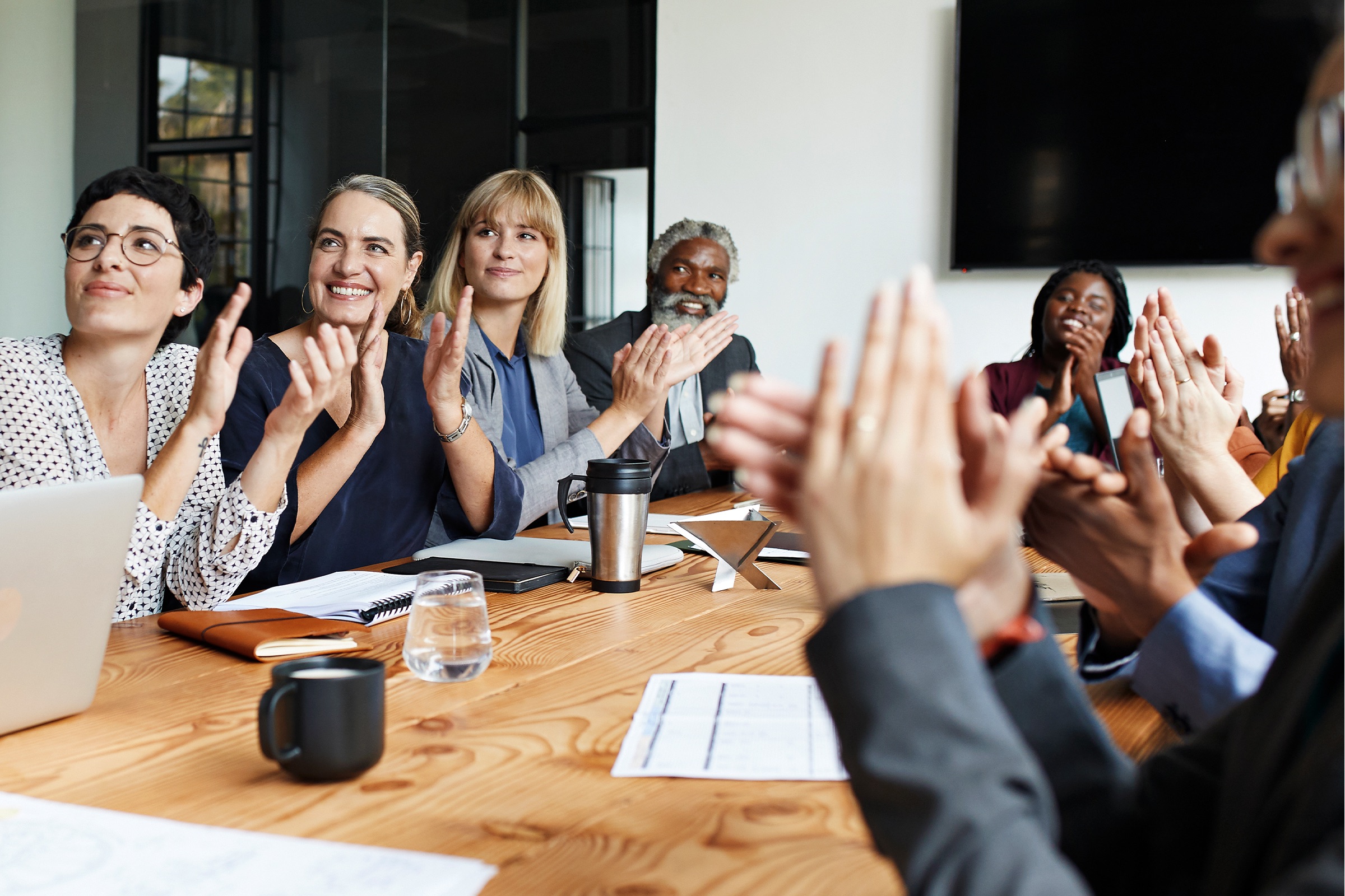 A group of people sitting at a table applauding